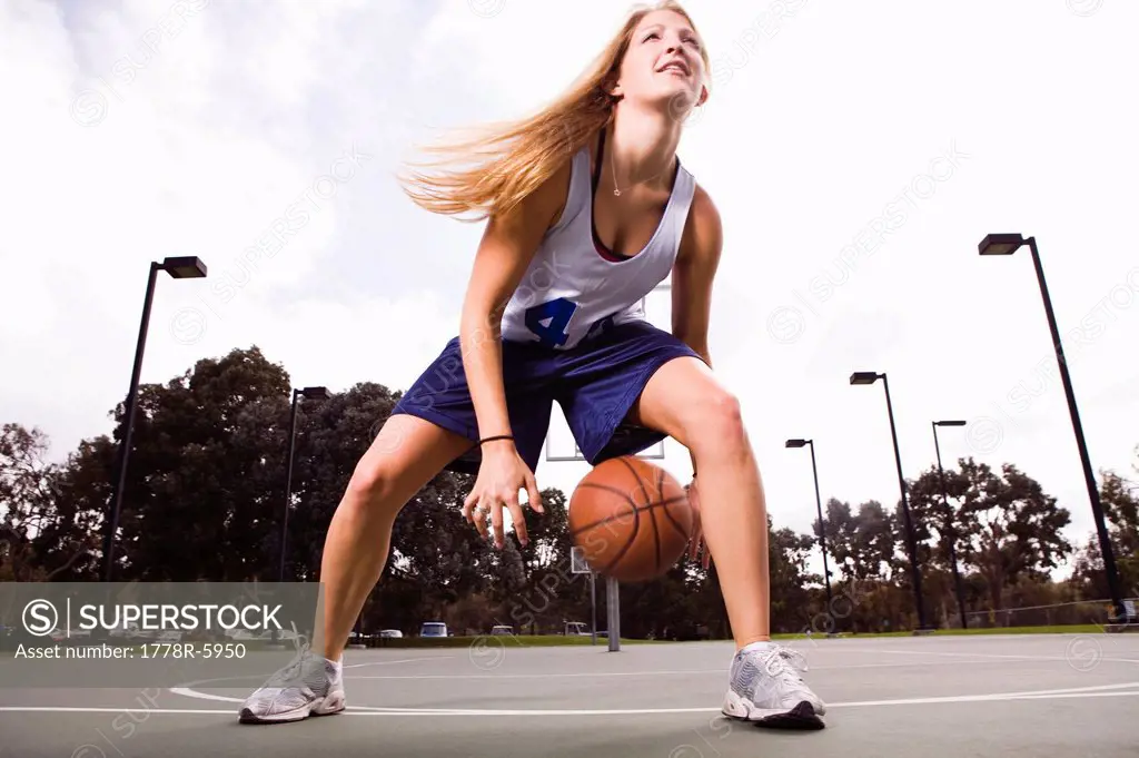 Action shot of a woman playing basketball.