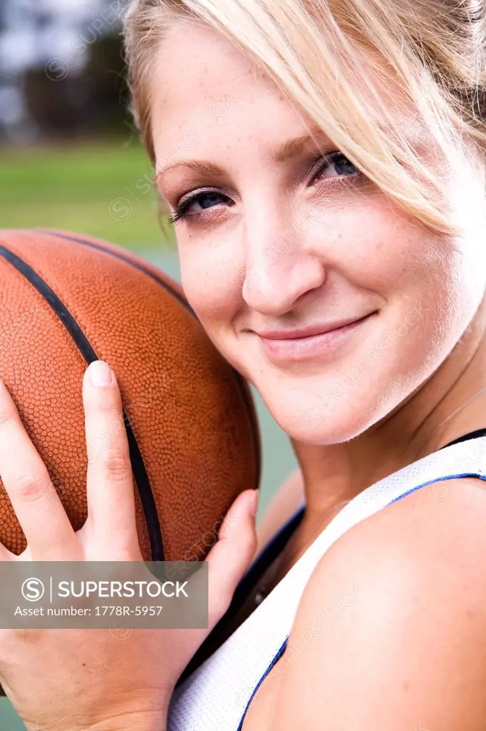 A portrait of an athletic woman playing basketball.
