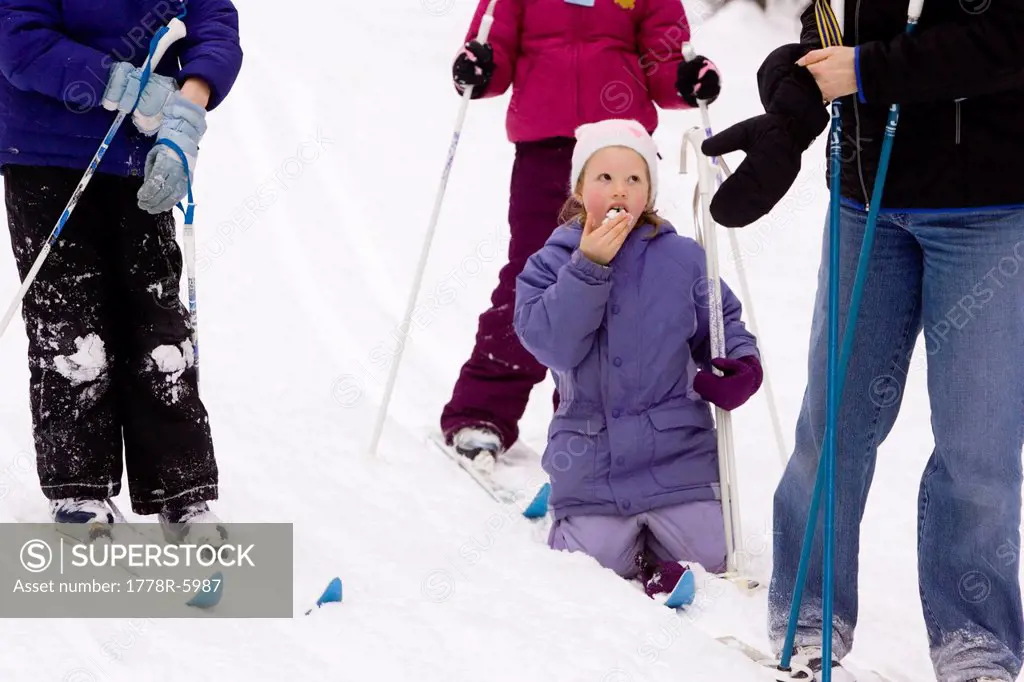 A young girl eat some snow, while Cross Country Skiing in Dayton, Maine.