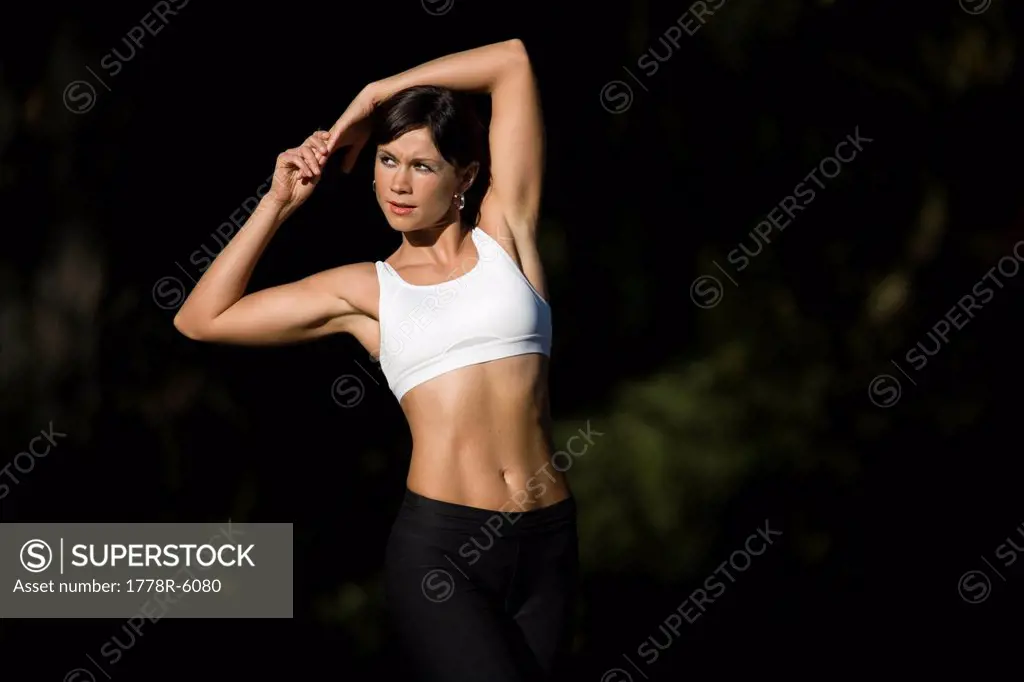 Young woman stretches outdoors in Portland, Oregon.
