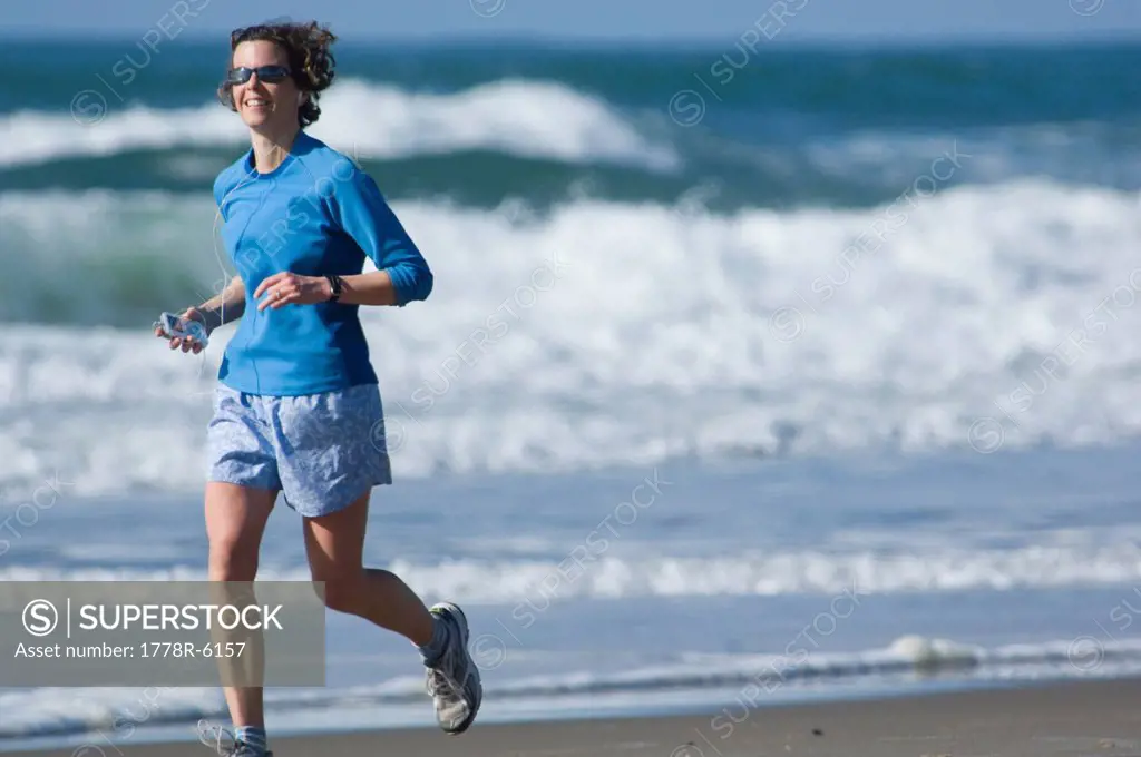 Woman running on beach, Oregon.