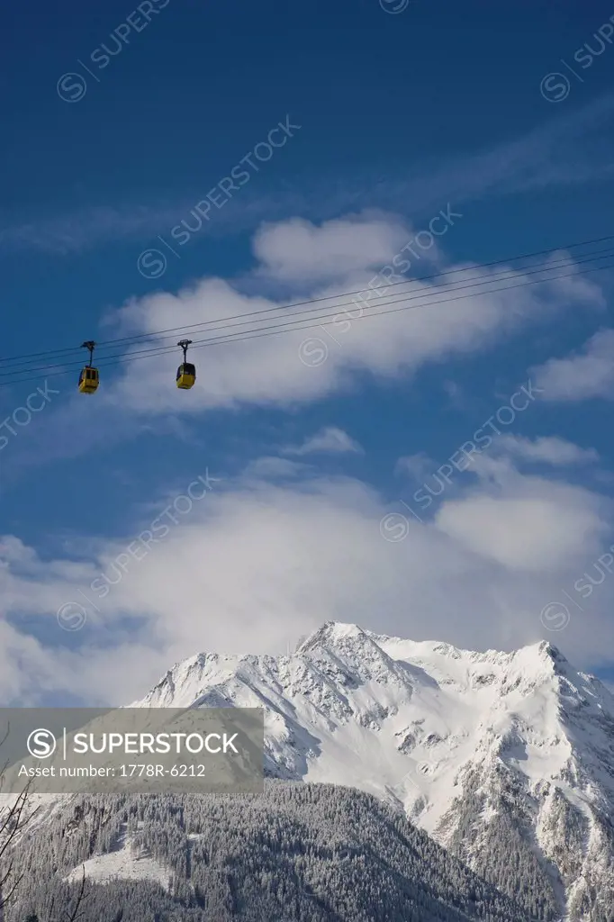 Cable cars hang high above the snowy ground near Mayrhofen, Austria.