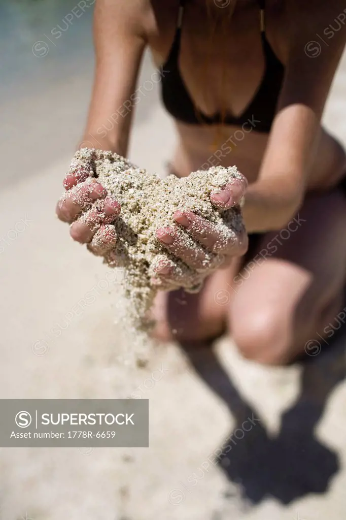 A woman holds a handful of sand in Loreto, Baja California Sur, Mexico.