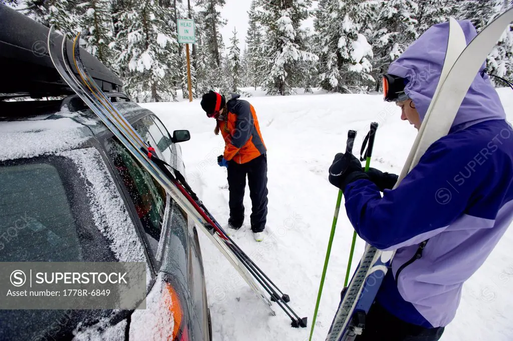 Two young women next to a car with cross country ski´s preparing to go nordic skiing in Bend, Oregon.