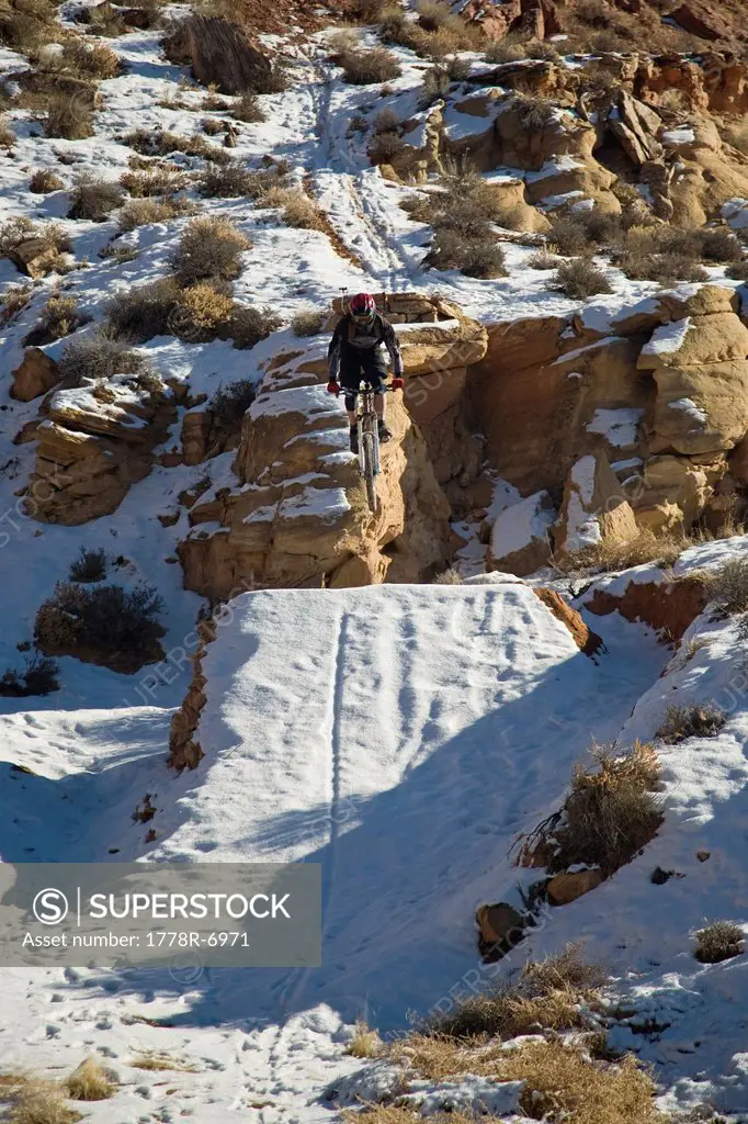 Mountain biker jumping with snowy landing in Moab, Utah.
