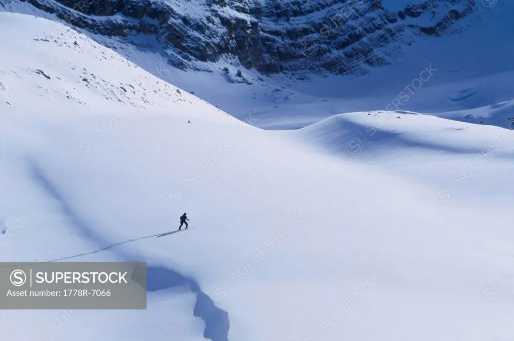 Solo skier skinning up a backcountry slope deep in the Canadian Rockies.