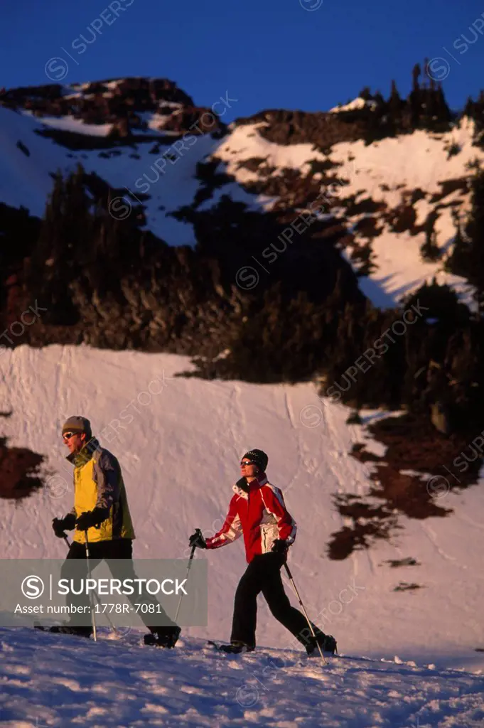 Couple snowshoeing on snowy mountain flanks in Mt. Rainier National Park, Washington.