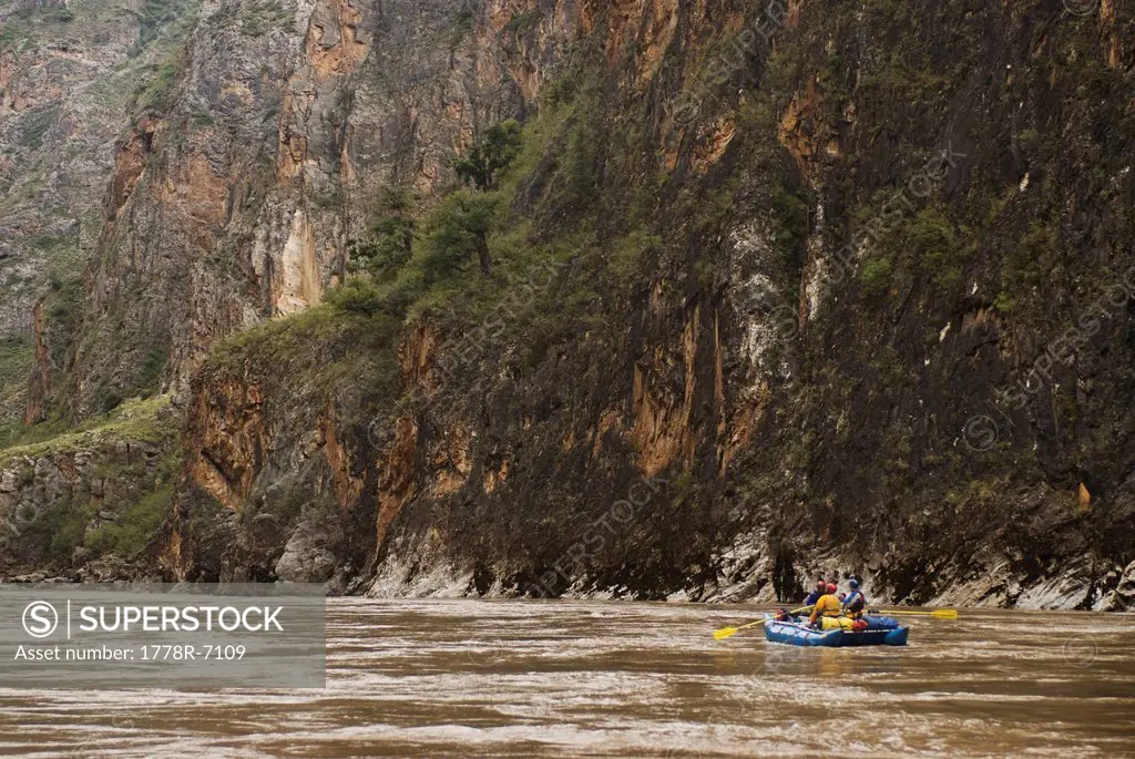 A rubber raft rows downstream during a whitewater rafting trip to Western China.