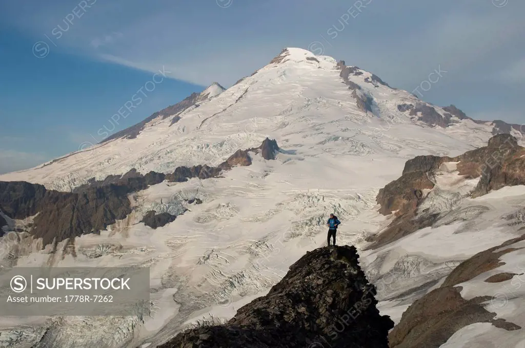 A woman standing on pinnacle below Mount Baker Mount Baker Wilderness, Bellingham, Washington.