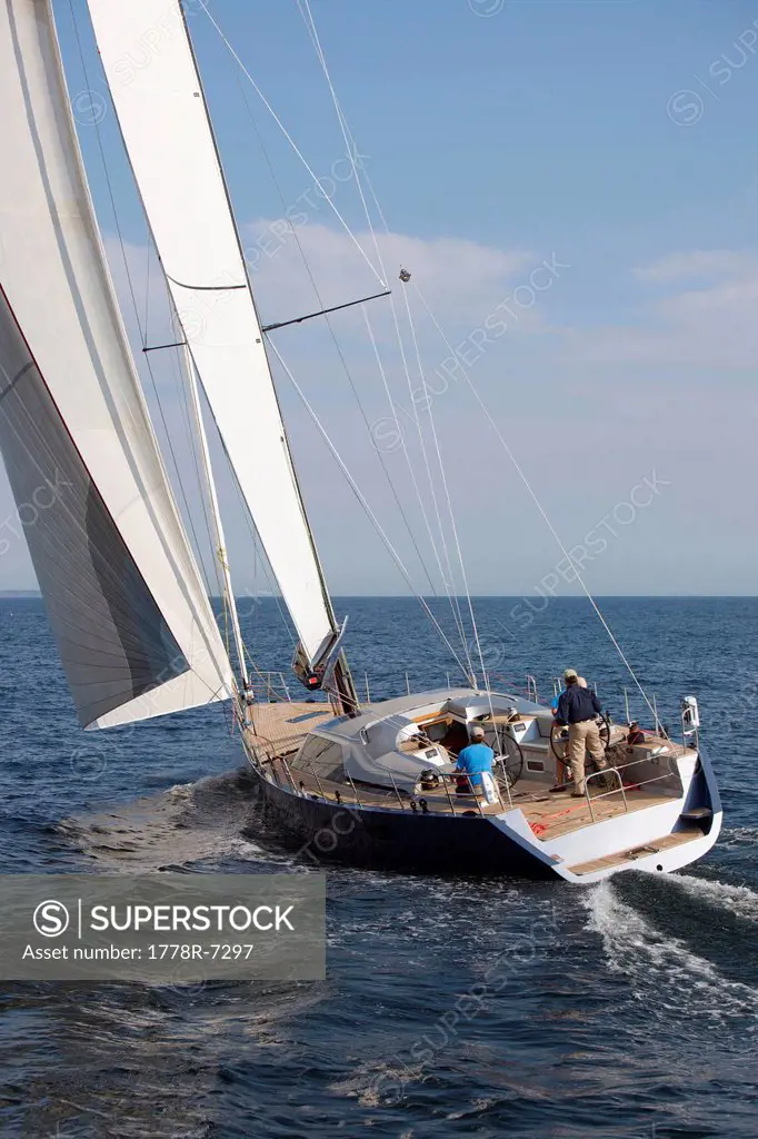 A crew races a modern ocean_going sailing yacht.