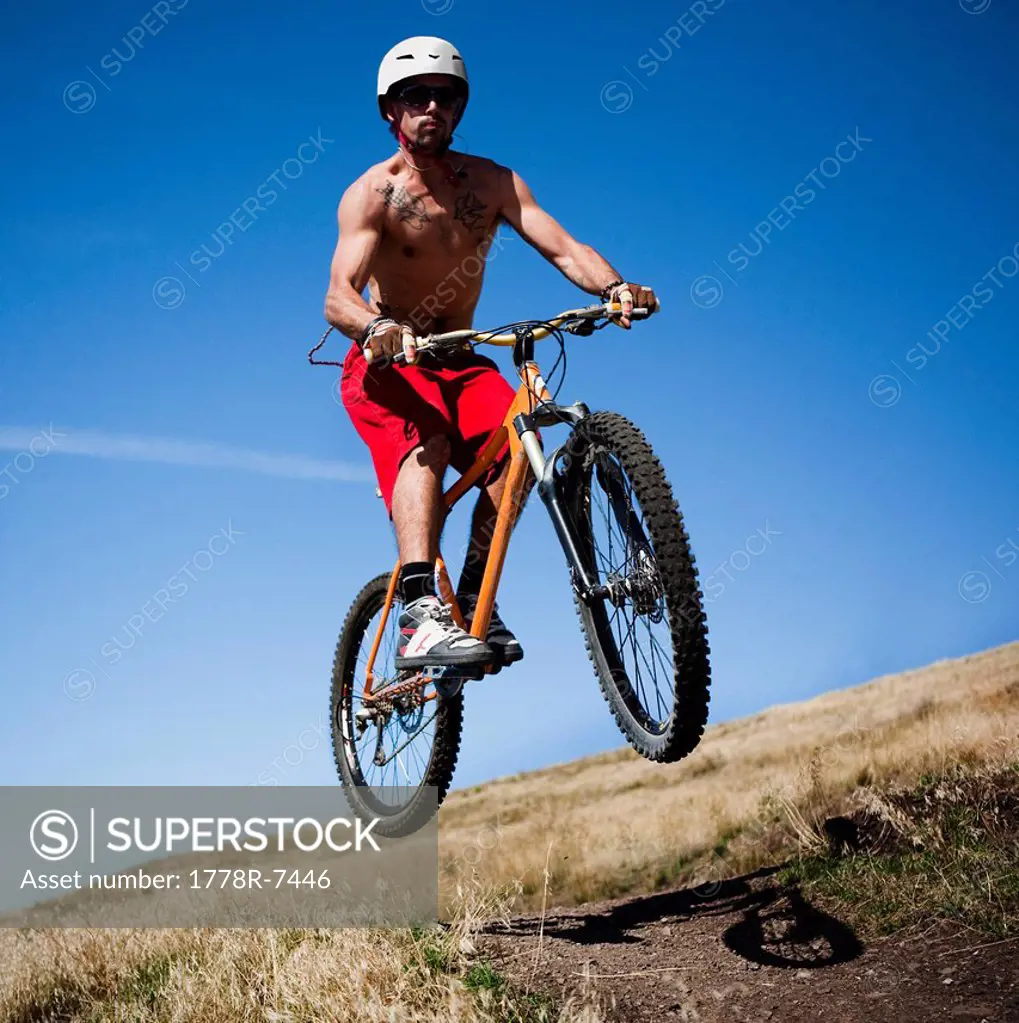 A male mountain biker gets air while riding a trail on Mt. Sentinel, Missoula, Montana.