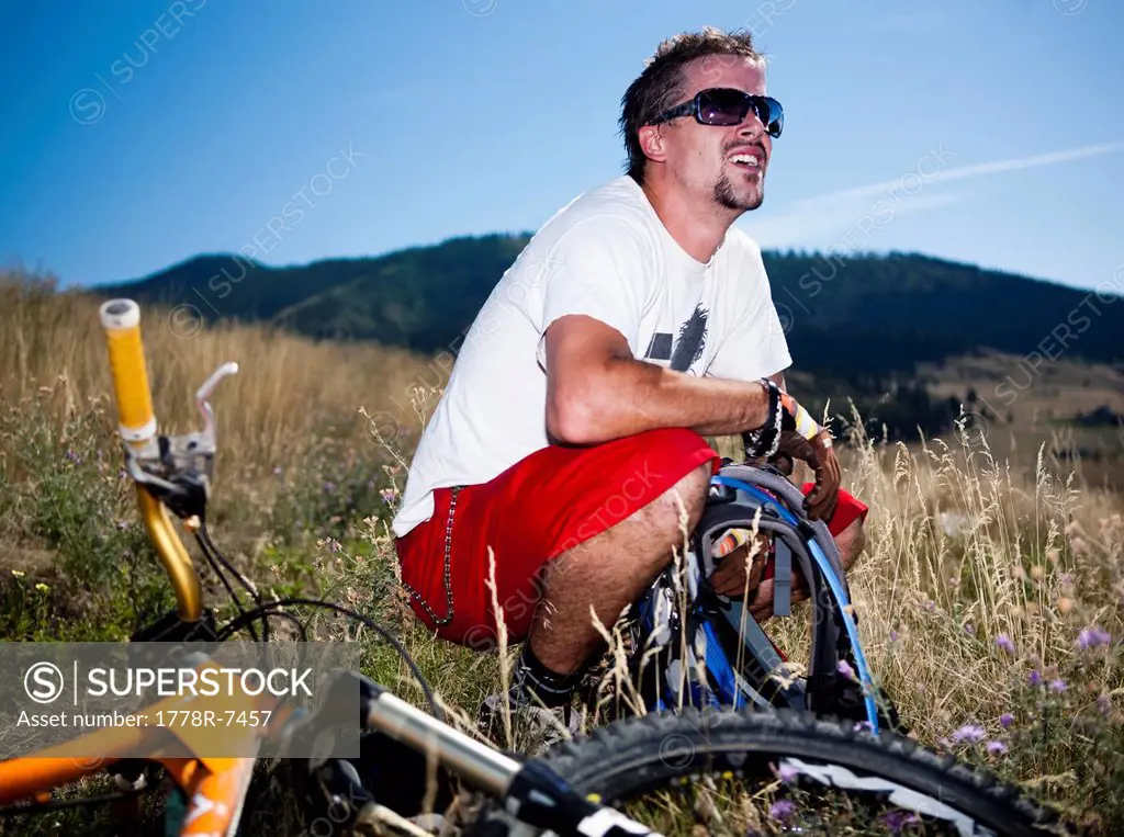 A male mountain biker stops to enjoy the view while riding the trails on Mt. Sentinel, Missoula, Montana.