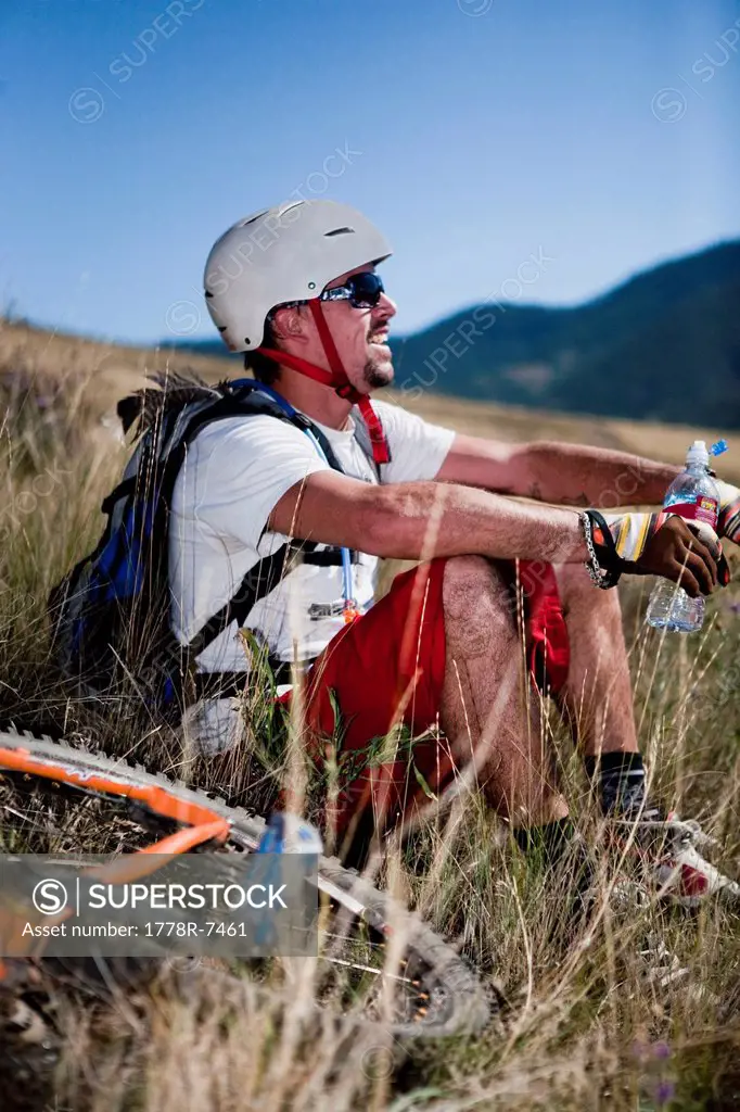 A male mountain biker stops for a water break after riding the trails on Mt. Sentinel, Missoula, Montana.