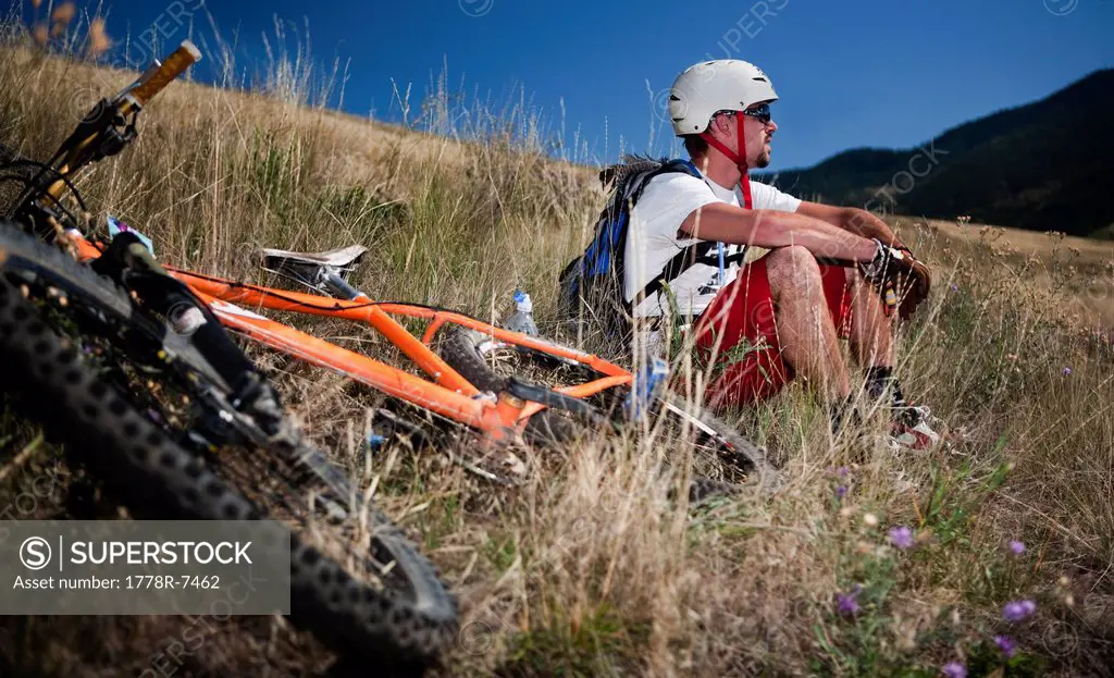 A male mountain biker stops for a break after riding the trails on Mt. Sentinel, Missoula, Montana.
