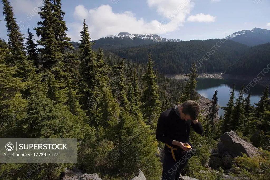 A man checks his location on a GPS global positioning system near Squamish, British Columbia.