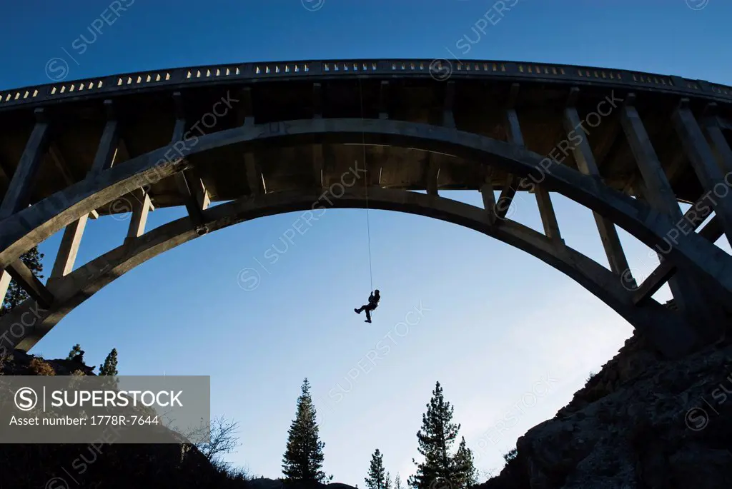 A young man ascends after rappelling off the Donner Pass Bridge in Truckee, California.
