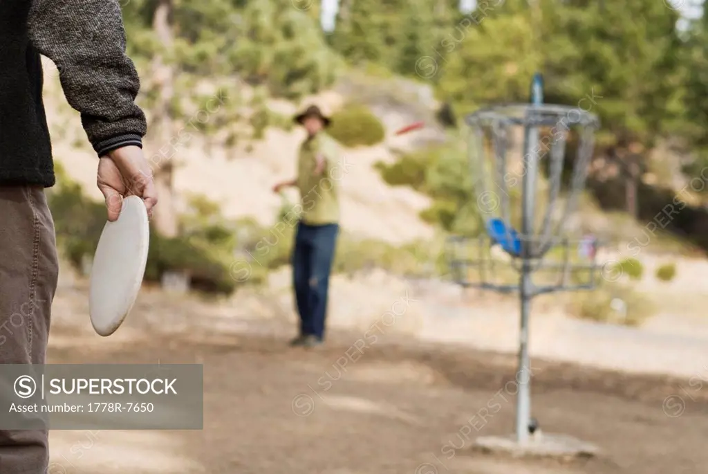Before playing a game of disc golf, a young man warms up on a practice basket in Lake Tahoe, California.