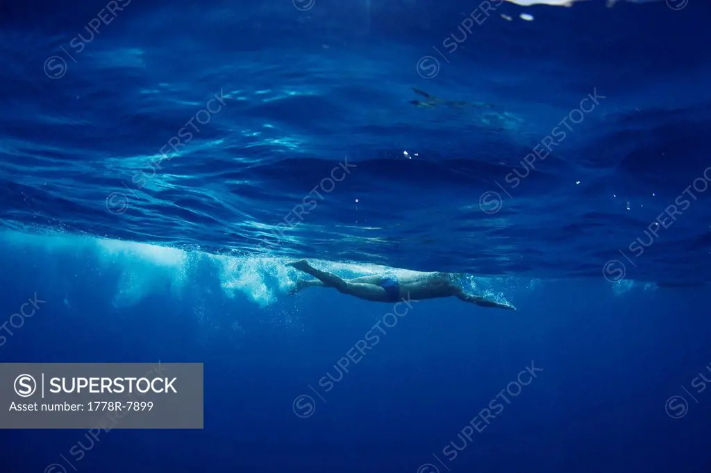 Underwater view of a swimmer enjoying a relaxing swim in the tropical waters off of Mana Island, Fiji.
