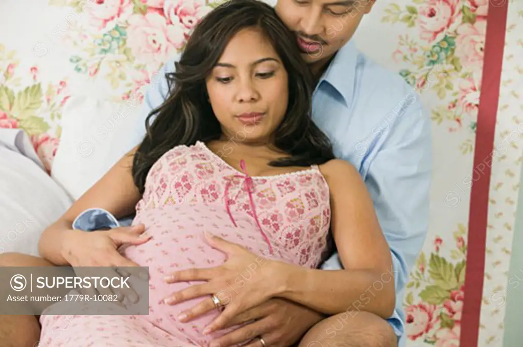 Hispanic man hugging pregnant wife