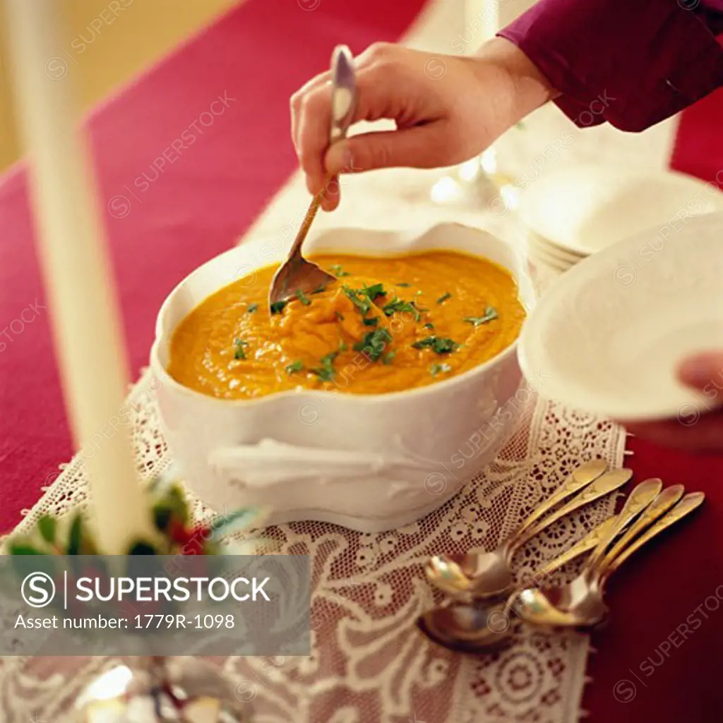 Close-up of person serving soup