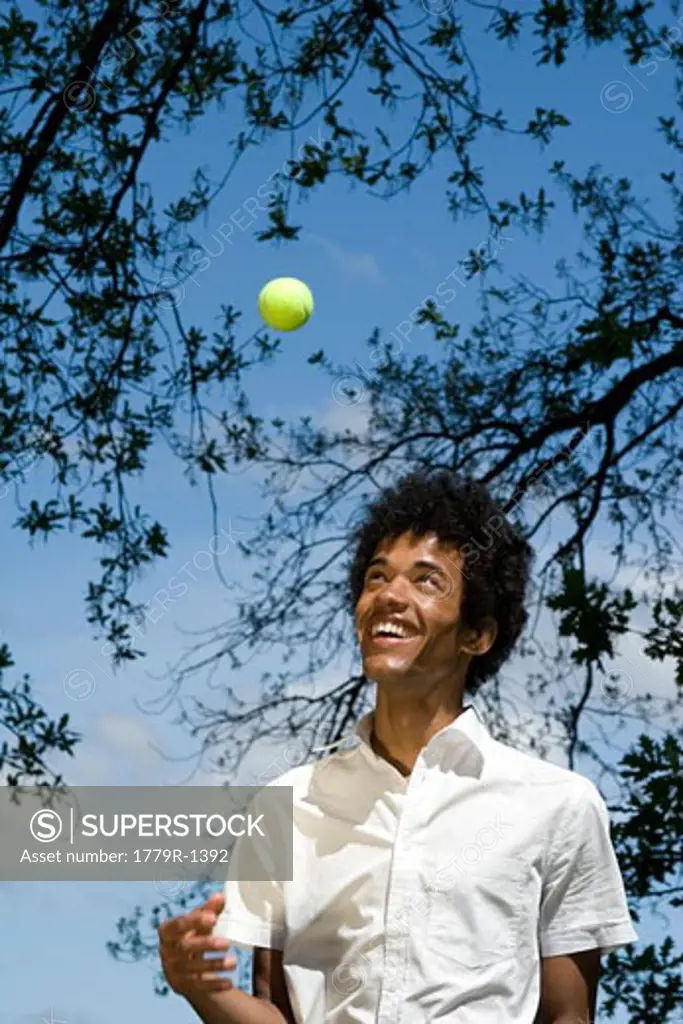 Man tossing tennis ball in the air
