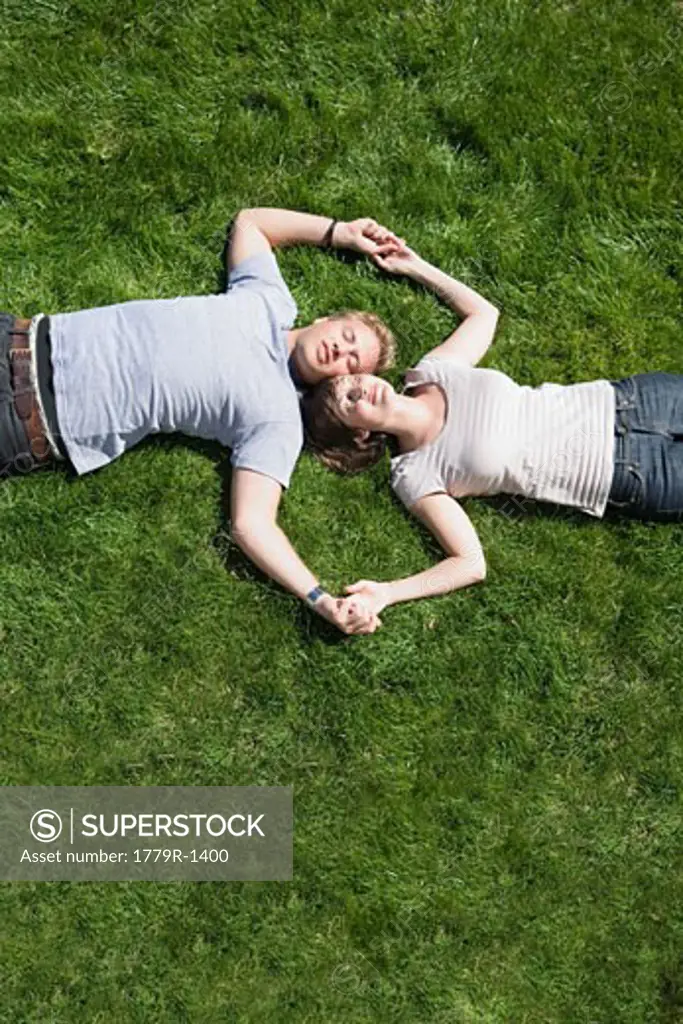 Couple holding hands on lawn