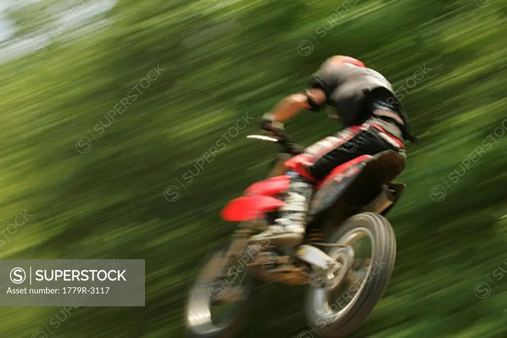 Blurred motorcyclist jumping mid-air