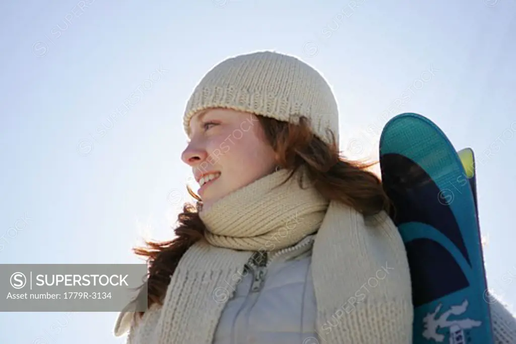 Young adult woman holding skiis