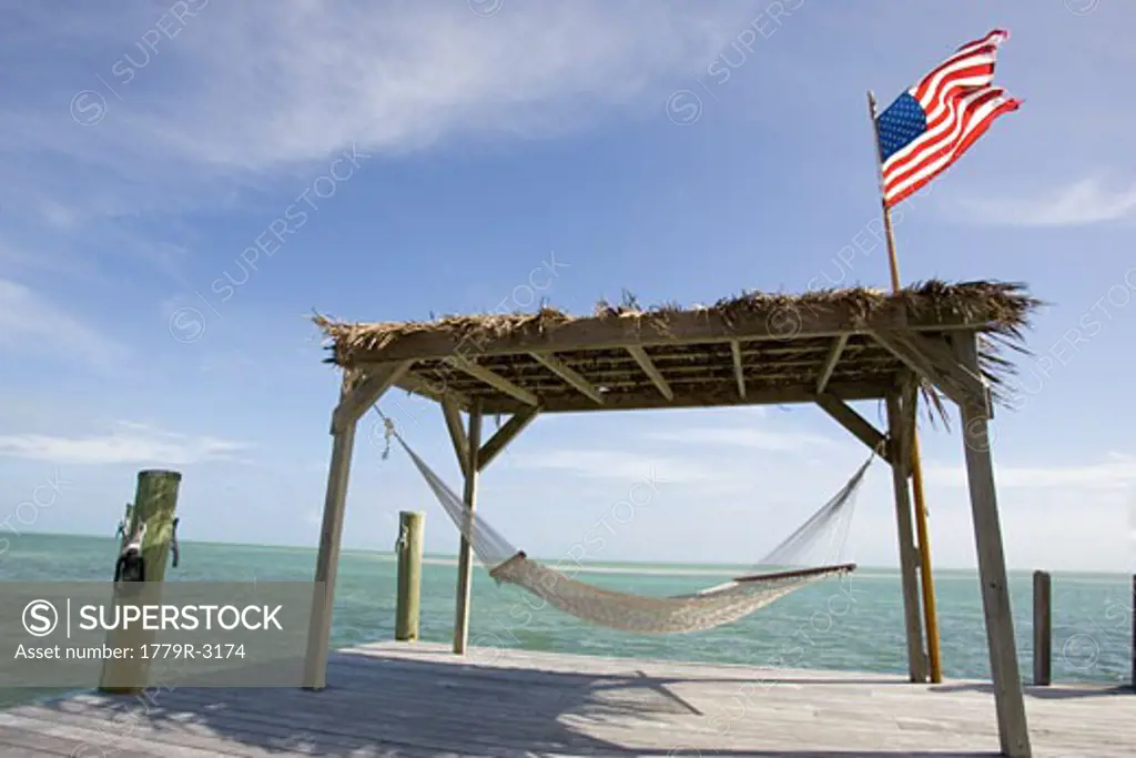 Empty hammock beneath hut with American flag in Islamorada, Florida