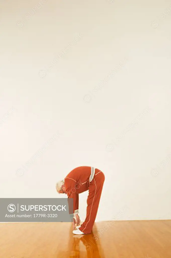 Senior man in sweat suit stretching