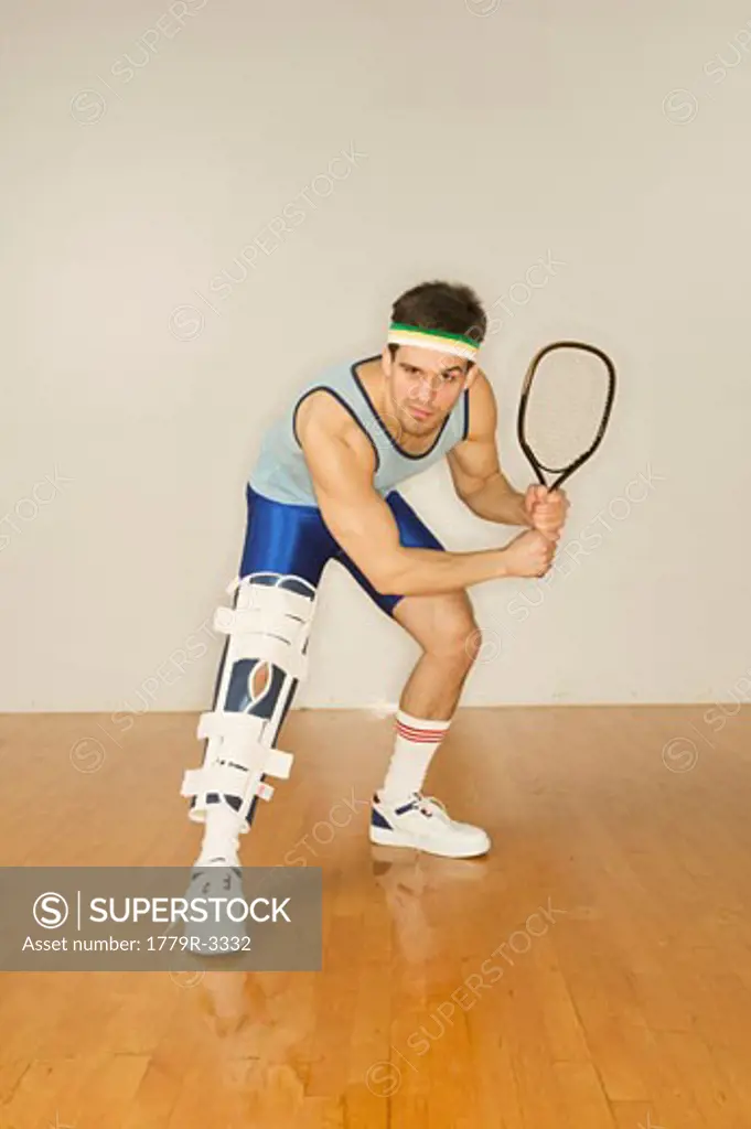 Man in leg brace holding racquetball racket