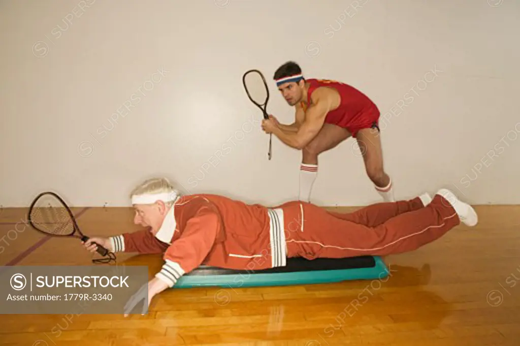 Young man and senior man playing racquetball