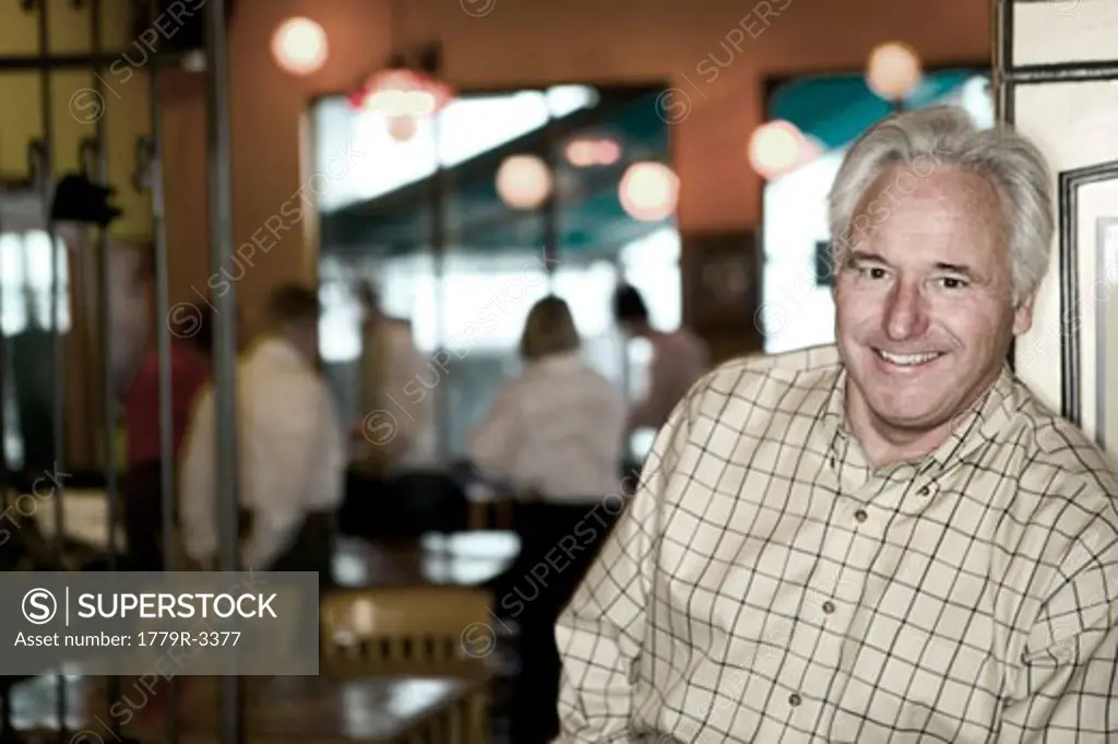 Senior man smiling in restaurant