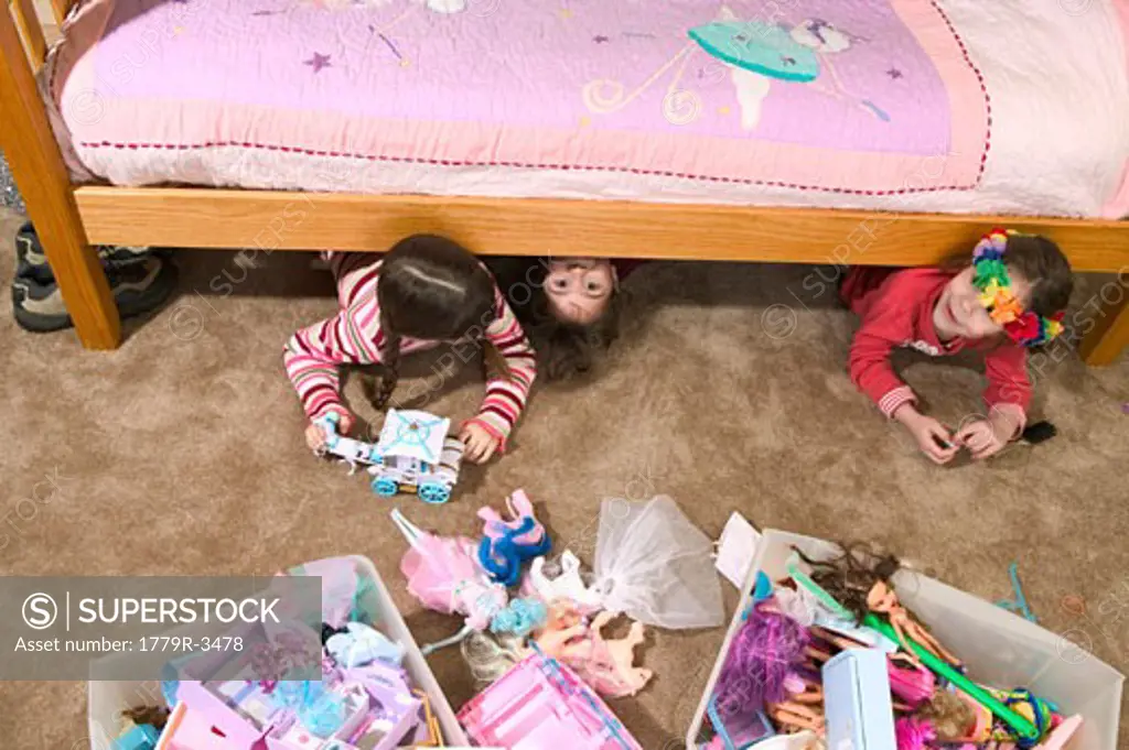 Young girls hiding under the bed