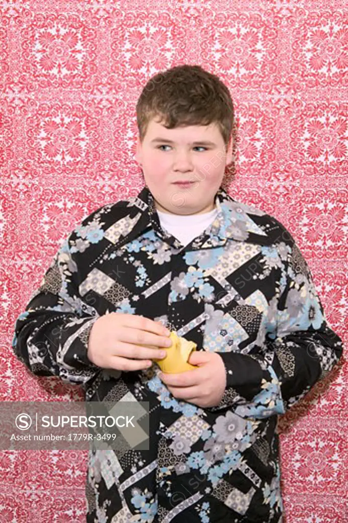 Dressed up young boy eating pear