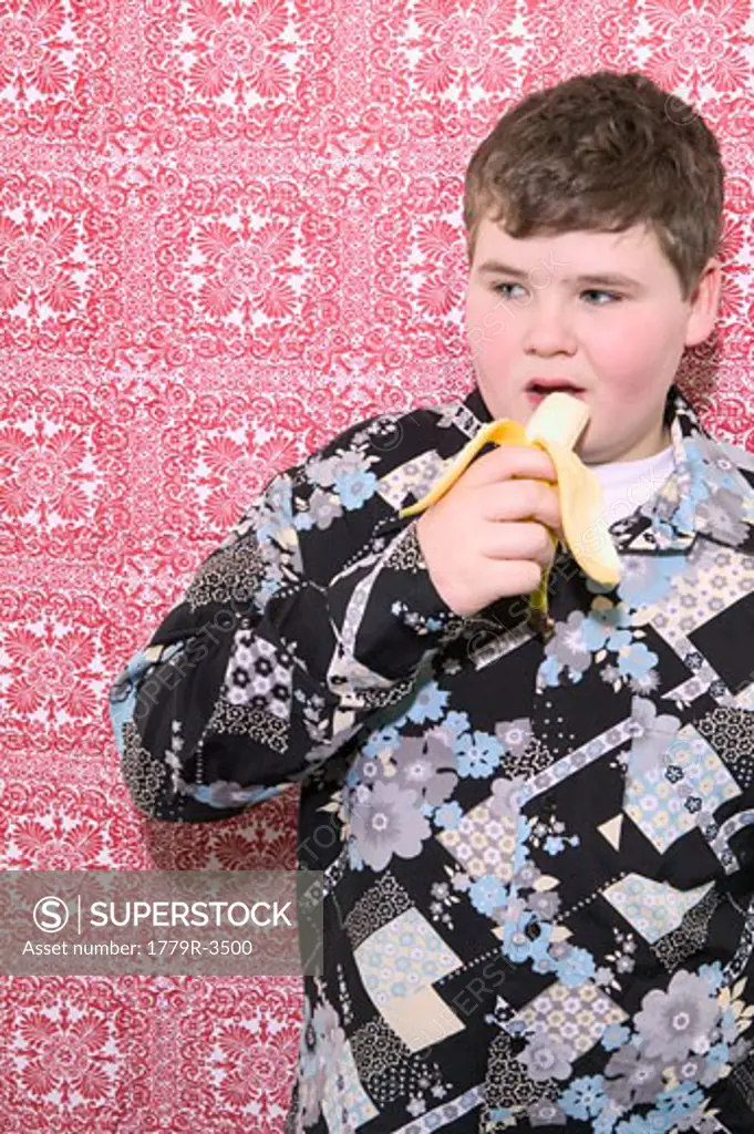 Young boy eating banana