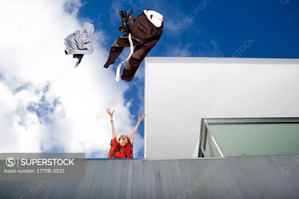 Woman throwing her husband's clothes over a balcony