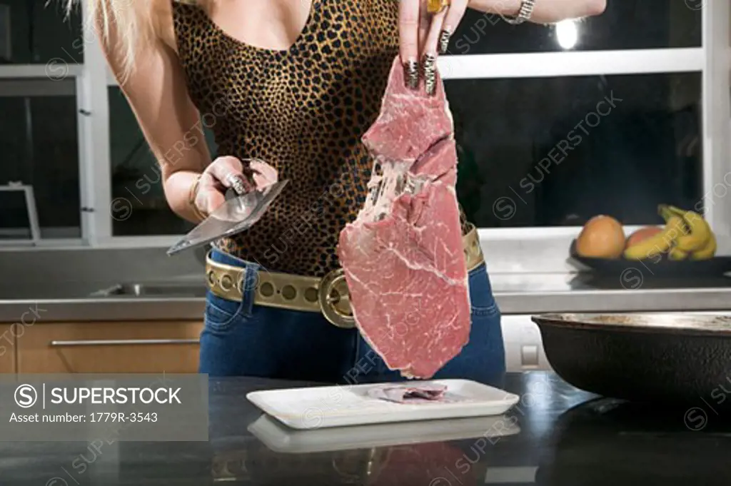 Glamorous woman cutting meat with a knife