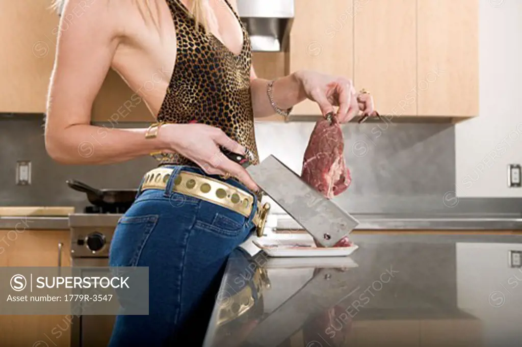 Glamorous woman cutting meat with a knife