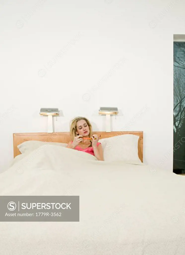 Woman admiring nails in bed