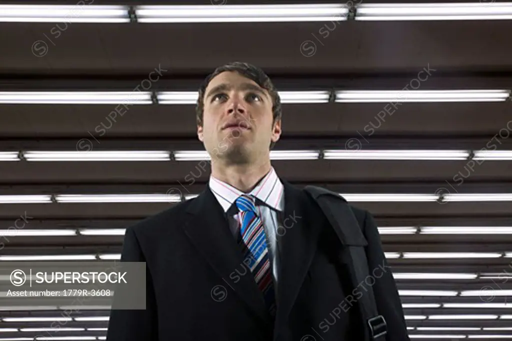Businessman walking beneath florescent lights