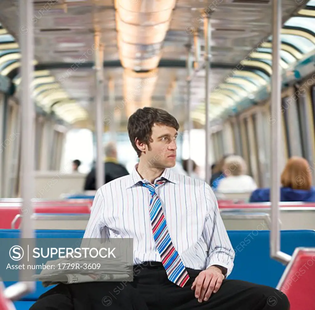 Businessman with newspapers on a train