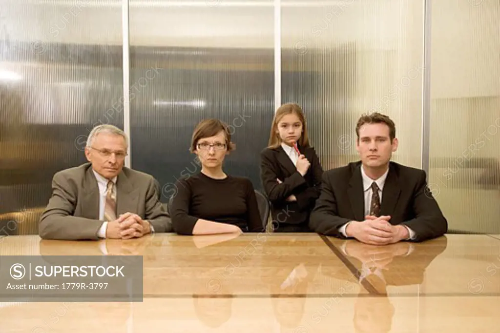 Businesspeople and young girl at conference table
