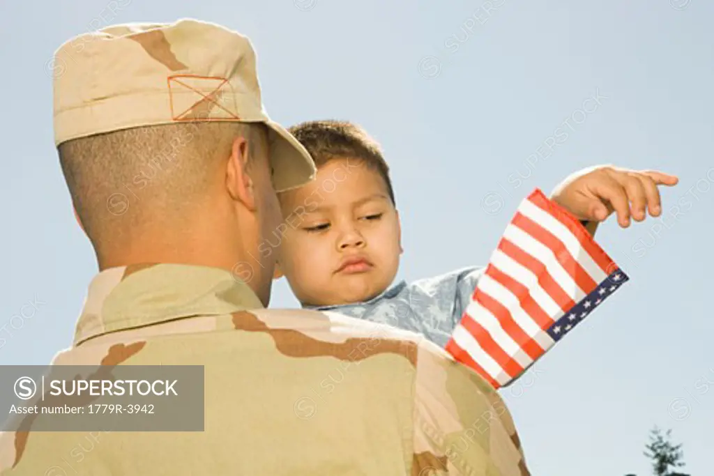 Hispanic military soldier holding son