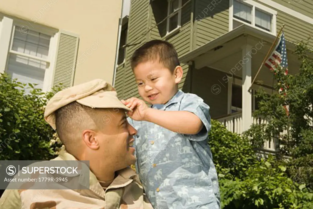 Hispanic military soldier playing with son