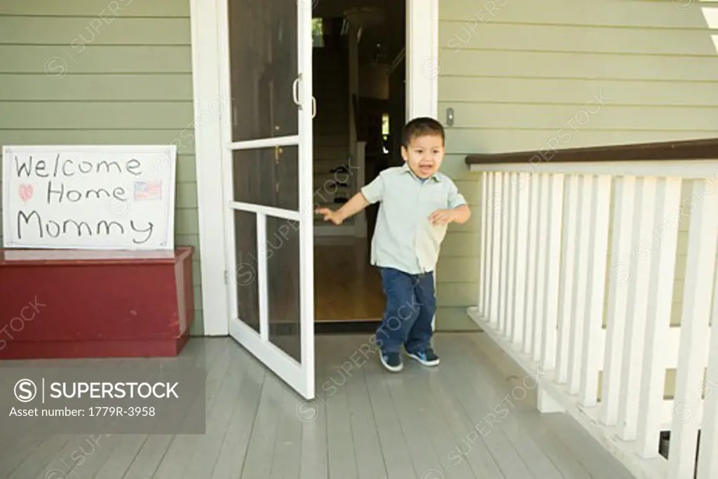 Hispanic boy running out front door