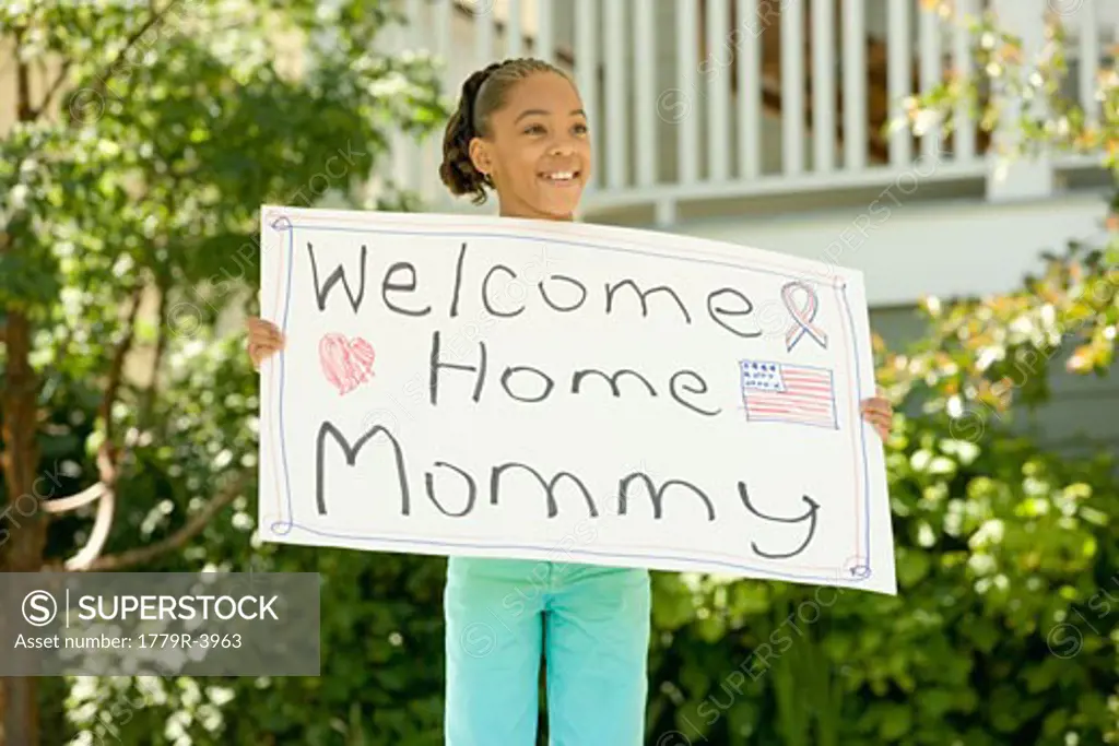 African girl holding "Welcome Home Mommy" sign