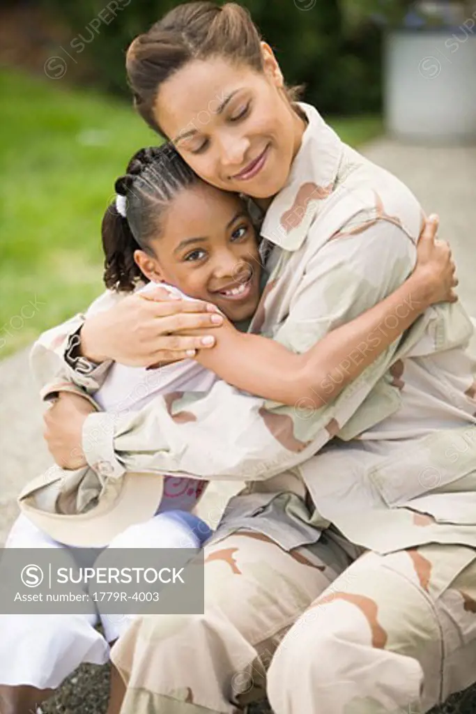 African military soldier hugging her daughter