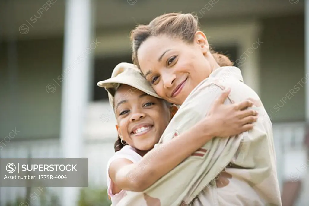 African military soldier hugging her daughter