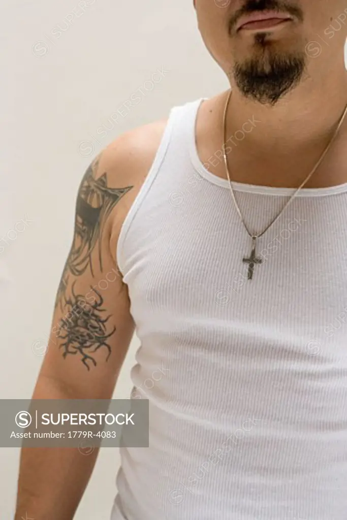 Tattooed Hispanic man wearing gold cross